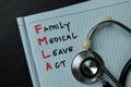 FMLA - Family Medical Leave Act write on a book isolated wooden table Royalty Free Stock Photo