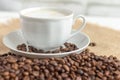 Foam coffee in a white Cup and coffee beans on the table, selective focus Royalty Free Stock Photo