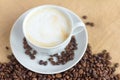 Foam coffee in a white Cup and coffee beans on the table, selective focus Royalty Free Stock Photo