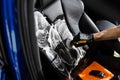 Foam and detergent cleaning leather seat using brush. Worker in auto cleaning service clean car inside. Car interior Royalty Free Stock Photo