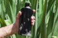 Foam on the male hand.Man holding plastic black bottle of shampoo Royalty Free Stock Photo