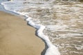 Foam from the ocean wave that washes the sand on the sea beach Royalty Free Stock Photo