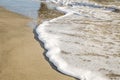 Foam from the ocean wave that washes the sand on the sea beach Royalty Free Stock Photo