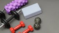 Foam rollers, dumbbells and yoga block on grey mat with massage roller. Set of fitness equipment on a gray background, front view Royalty Free Stock Photo