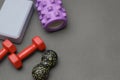 Foam rollers, dumbbells and yoga block on grey mat with massage roller. Set of fitness equipment on a gray background, front view Royalty Free Stock Photo