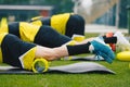 Foam Rolling. Group of Young Soccer Players in Soccer Cleats Using Training Foam Roller on Training Session