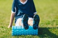 Foam Rolling. Young Soccer Player in Soccer Cleats Using Training Foam Roller Royalty Free Stock Photo