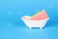 Foam sponge in a stand in the form of a bathtub on a blue background Royalty Free Stock Photo