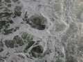 Foam stirred sea background in white, blue and grey