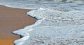 Foam waves on sandy beach