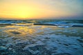 Foam waves on the sea coast during sunrise