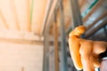 Foamed construction foam in orange color close-up against the background of bare walls in an unfinished house