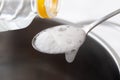 Foaming baking soda slaked with vinegar in a spoon over a metal dish