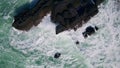 Foaming sea water breaking on stone cliff. Aerial stormy rough ocean crashing Royalty Free Stock Photo