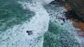 Foaming water waving beach rocks close up. Ocean surf washing pebble coastline