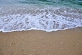 A foaming wave comes to the sand beach like a high tide.Sea sandy shore with an oncoming foam wave.