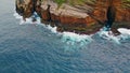 Foaming waves crashing rocky coastline aerial. Wild sea washing reef rock cliffs Royalty Free Stock Photo