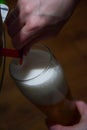 Foamy beer is poured from a beer barrel into a glass goblet