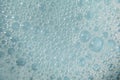 Foamy cosmetic texture with bubbles on blue background. Cleanser, shampoo, wash - liquid soap, shower gel, hyaluronic Royalty Free Stock Photo