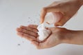 Foamy face wash in hands on white background