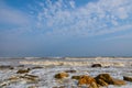Foamy gray waves beat against coastal stones