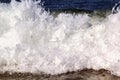 Foamy ocean wave breaks out onto the sandy shore during the surf Royalty Free Stock Photo