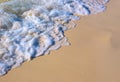 Foamy sea tide on white sand beach. Sea tide on yellow sand. Tropical seaside photo. Marine holiday