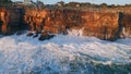 Foamy sea water hitting dangerous coastal rocks drone view. Stormy ocean waves Royalty Free Stock Photo