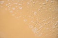 Foamy sea water over yellow sand beach. Tropical seaside concept photo. Seawater on sand beach Royalty Free Stock Photo