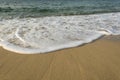 Foamy soft wave on sand beach Royalty Free Stock Photo