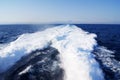 Foamy trace of a wave set off by a ship in the blue sea Royalty Free Stock Photo