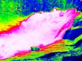 Foamy water level of waterfall, curves between boulders of rapids. Water of mountain river in infrared photo. Amazing thermography