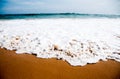 Foamy wave on beach sand Royalty Free Stock Photo