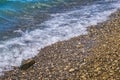 Foamy wave on pebble beach Royalty Free Stock Photo