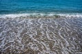 Foamy wave reaching the calm beach. Front view Royalty Free Stock Photo