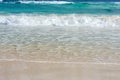 A foamy wave runs over the sandy beach. Seascape turquoise ocean and sandy coast against the blue sky. Rest by the sea. Royalty Free Stock Photo