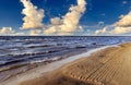 Foamy waves in the Baltic Sea against the blue sky with fluffy clouds on sunset in Jurmala