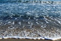 Foamy waves in blue sea with beach Royalty Free Stock Photo