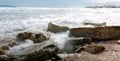 Foamy waves roll on rocky beach