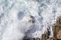 Foamy waves of the surf near the rocky shore