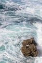 Foamy waves of the surf near the rocky shore