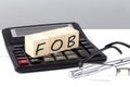 FOB concept on wooden cubes on calculator on white background Royalty Free Stock Photo
