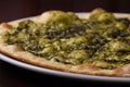 Focaccia with cheese and pesto on white dish on a dark wooden table Royalty Free Stock Photo