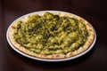 Focaccia with cheese and pesto on white dish on a dark wooden table Royalty Free Stock Photo