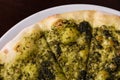 Focaccia with cheese and pesto on white dish on a dark wooden table Royalty Free Stock Photo