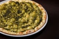 Focaccia with cheese and pesto on white dish on a dark wooden table Royalty Free Stock Photo