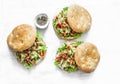 Focaccia sandwich with green salad, grilled chicken, avocado tomato salsa and yogurt sauce on light background, top view Royalty Free Stock Photo