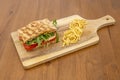 Focaccia sandwich with tomato, sliced buffalo cheese, dehydrated tomato and arugula in quantity with a garnish Royalty Free Stock Photo