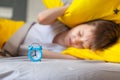 Focus on the alarm clock. Child trying to sleep, when alarm clock ringing. Time to wake up Royalty Free Stock Photo