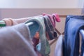 Focus on ankle socks drying on a laundry rack with other woman`s clothes, including blue jeans. Mismatched socks and pair of Royalty Free Stock Photo